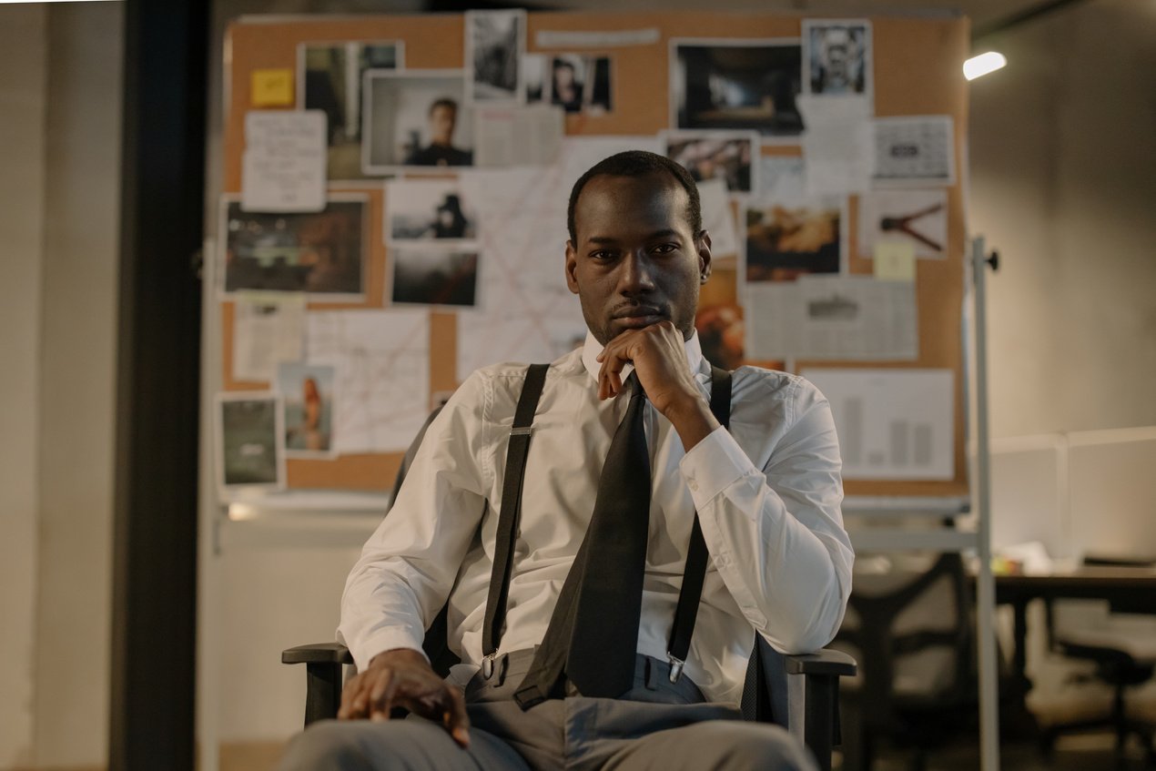 Man in White Dress Shirt and Black Necktie Sitting on Chair